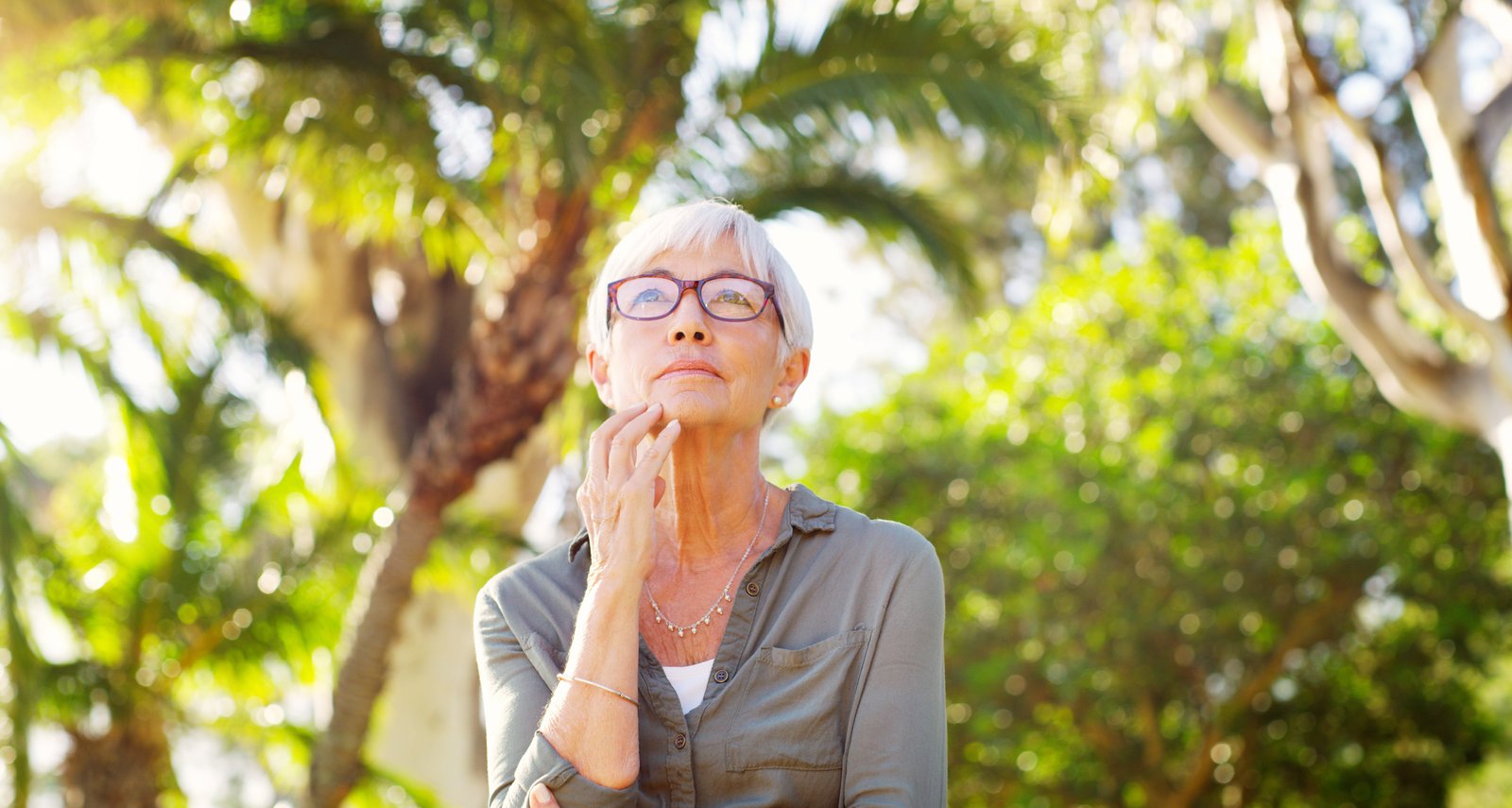 Whats your advice to your younger self. a senior woman looking thoughtful at the park