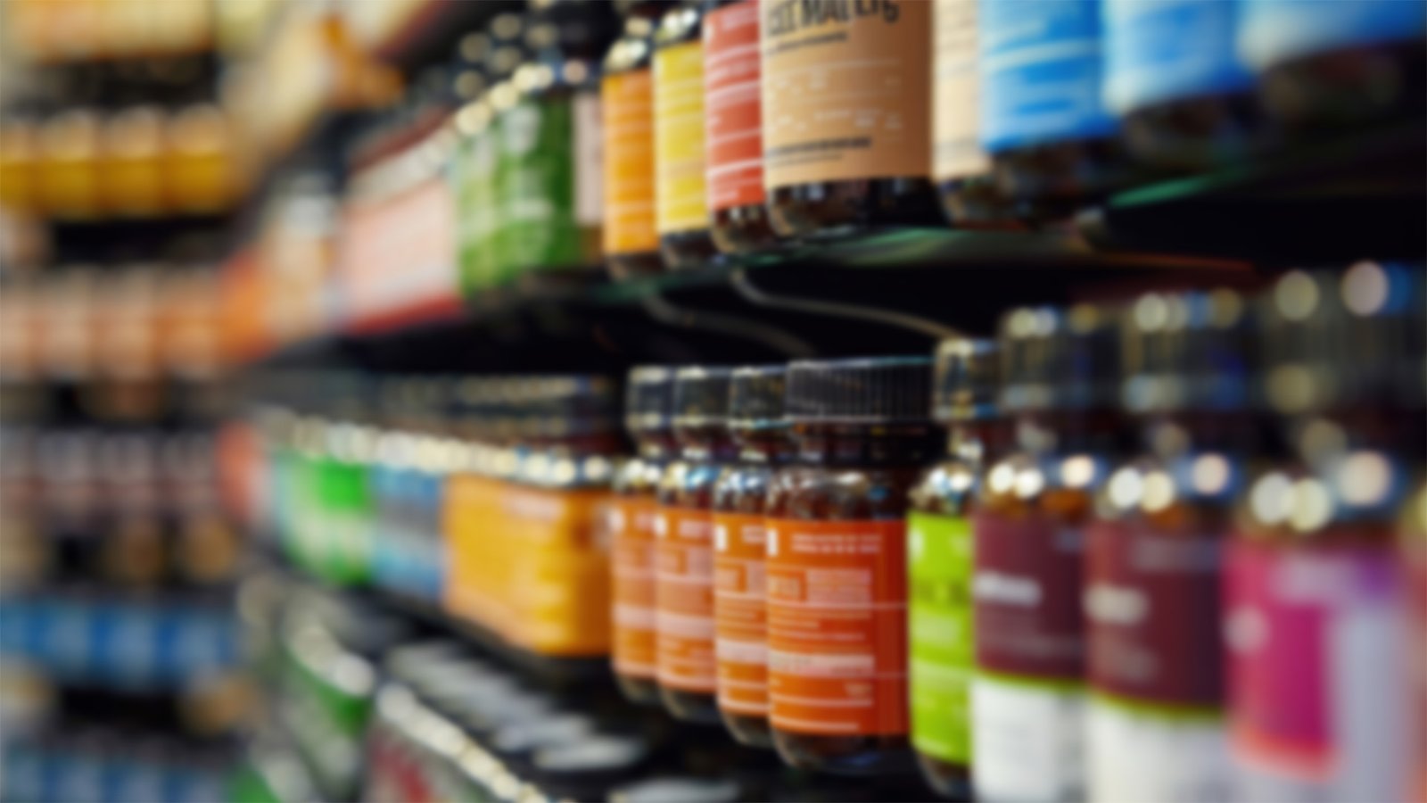 Rows of brightly colored supplement bottles lined up on store shelves, shown out of focus.